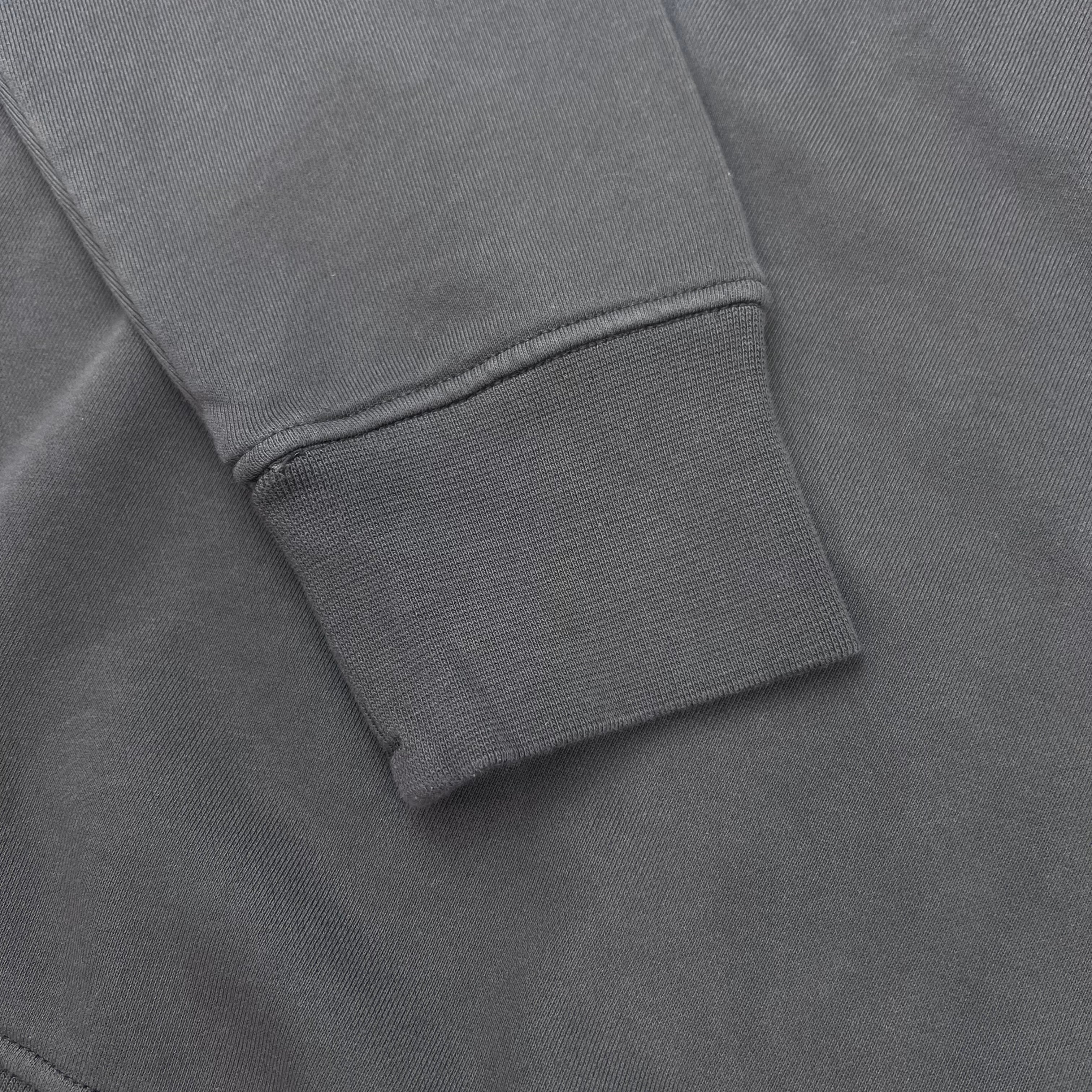 A close up view of the cuffs on a Stone Island Crewneck Sweatshirt in Charcoal Grey.