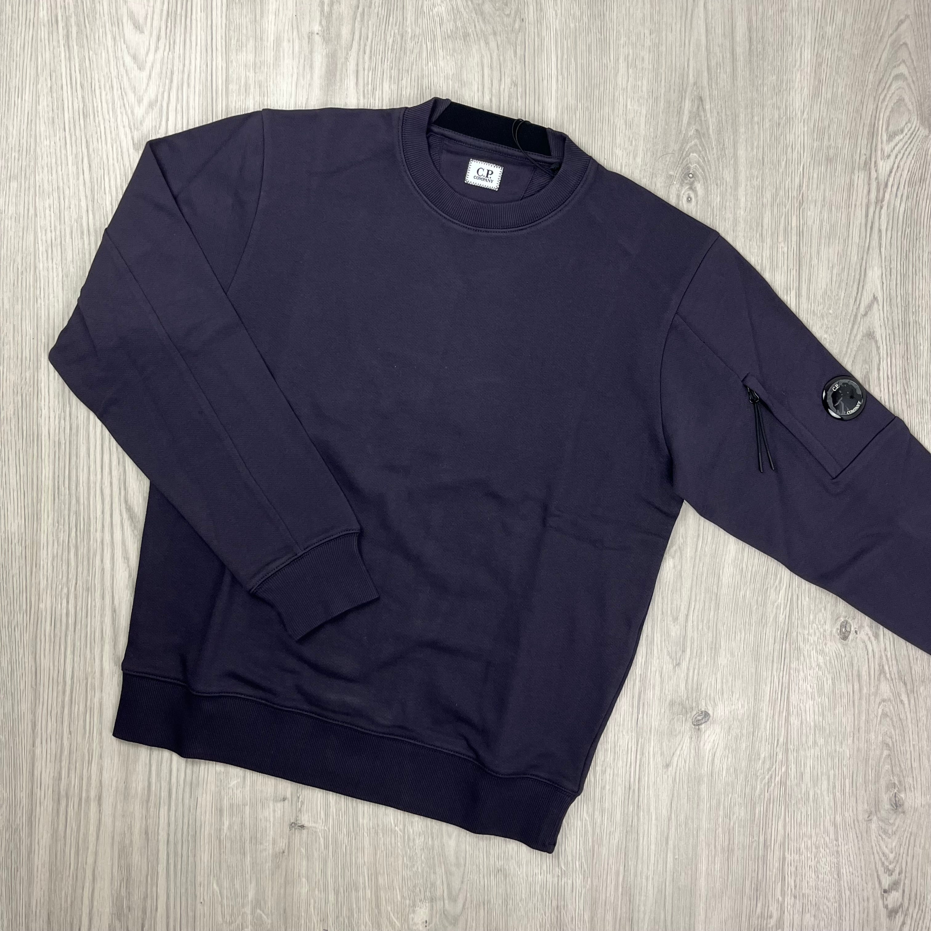 CP Company Diagonal Raised Fleece Crew Neck Lens Sweatshirt in Nightshade Purple. On sale at Open Attire.