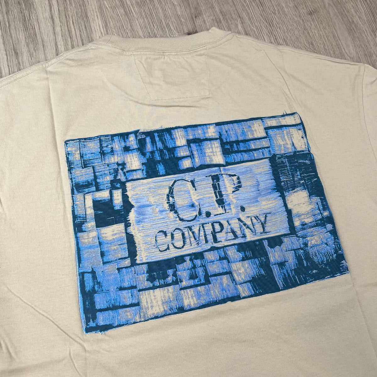 Rear view of the printed logo on a CP Company 30/1 Jersey Graphics T-Shirt in Silver Birch. 