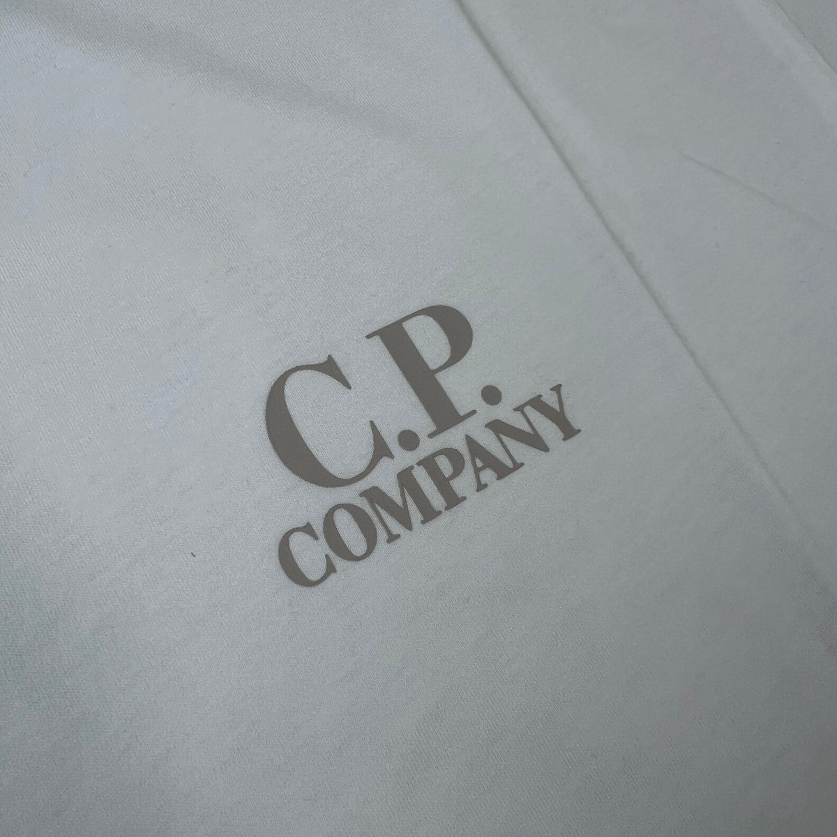 Close up view of the printed logo on a CP Company 30/1 Logo T-Shirt in Gauze White. 