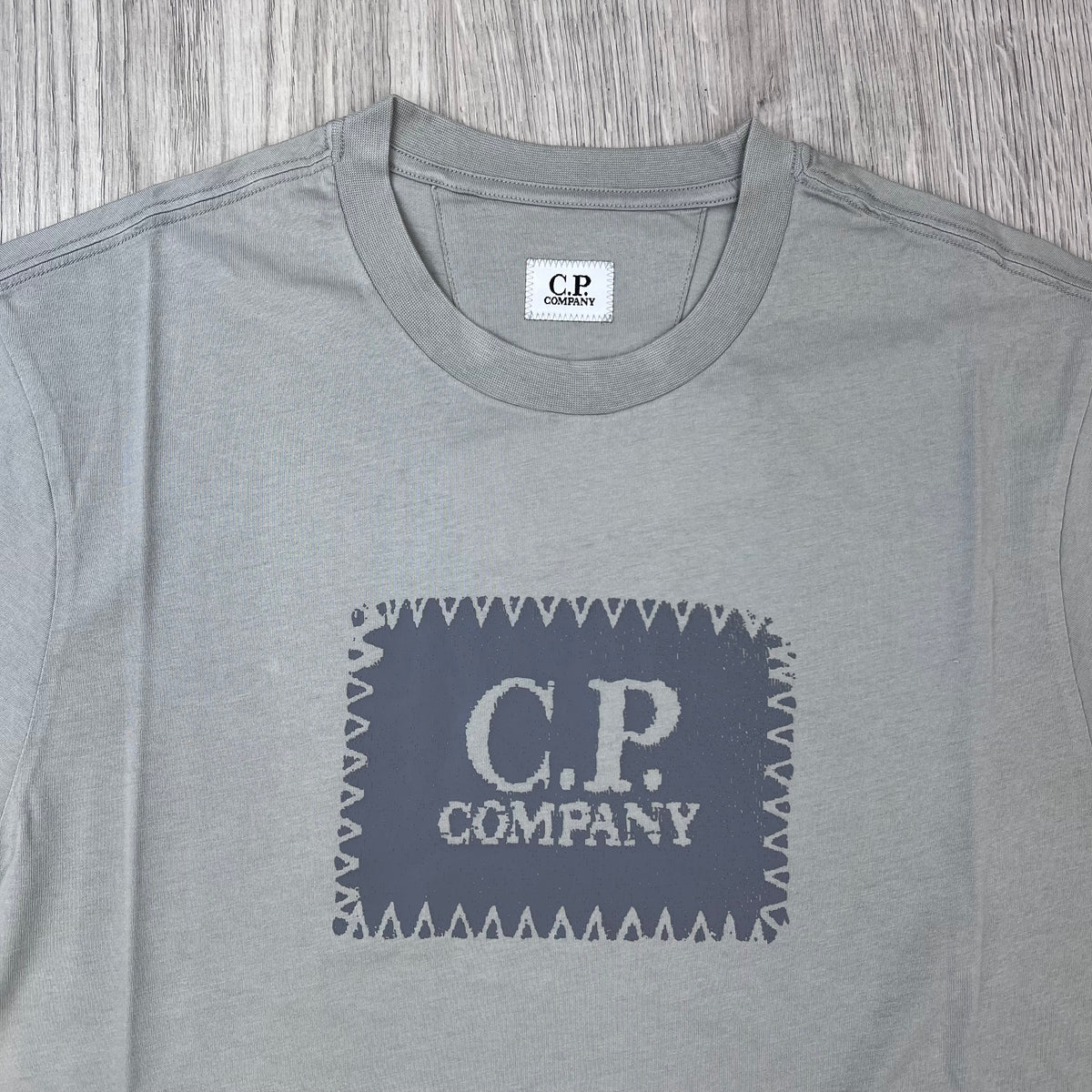 Close up view of the crewneck collar on a CP Company 30/1 Stamp T-Shirt in Flint Grey.
