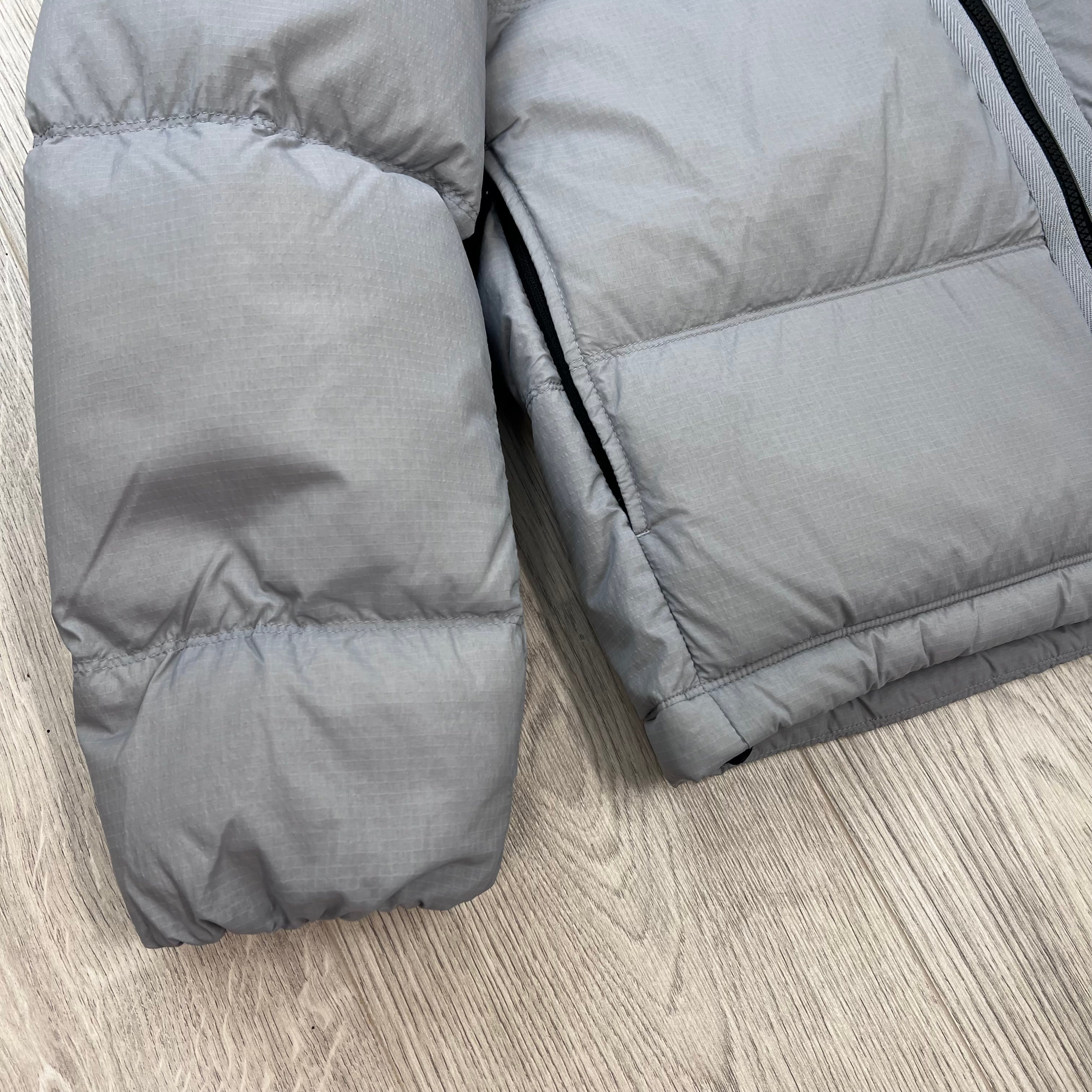 Close up view of the cuff and hem on a Stone Island Matt Ripstop CORDURA® Down Jacket in Ash Grey.