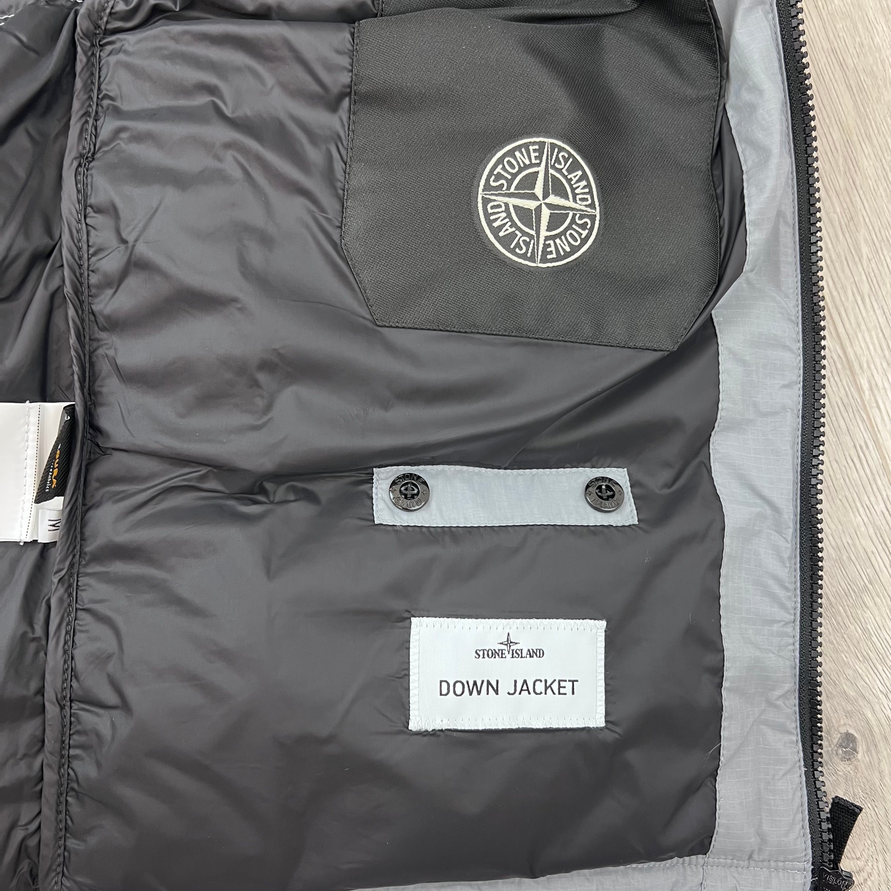 A close view of the inside labels on a Stone Island Matt Ripstop CORDURA® Down Jacket in Ash Grey.