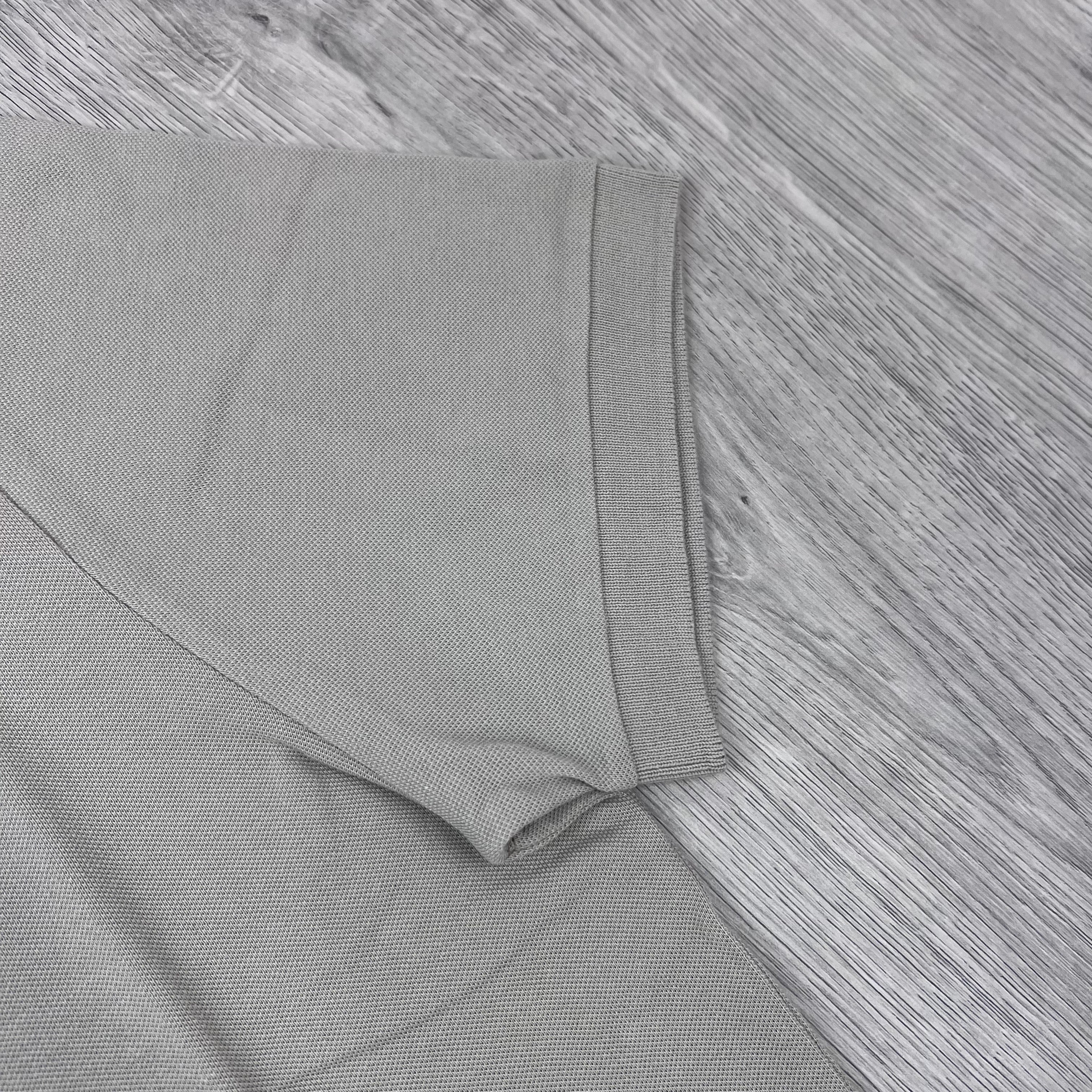 A close up front view of the cuff on a  Stone Island Patch Polo Shirt in Sand.