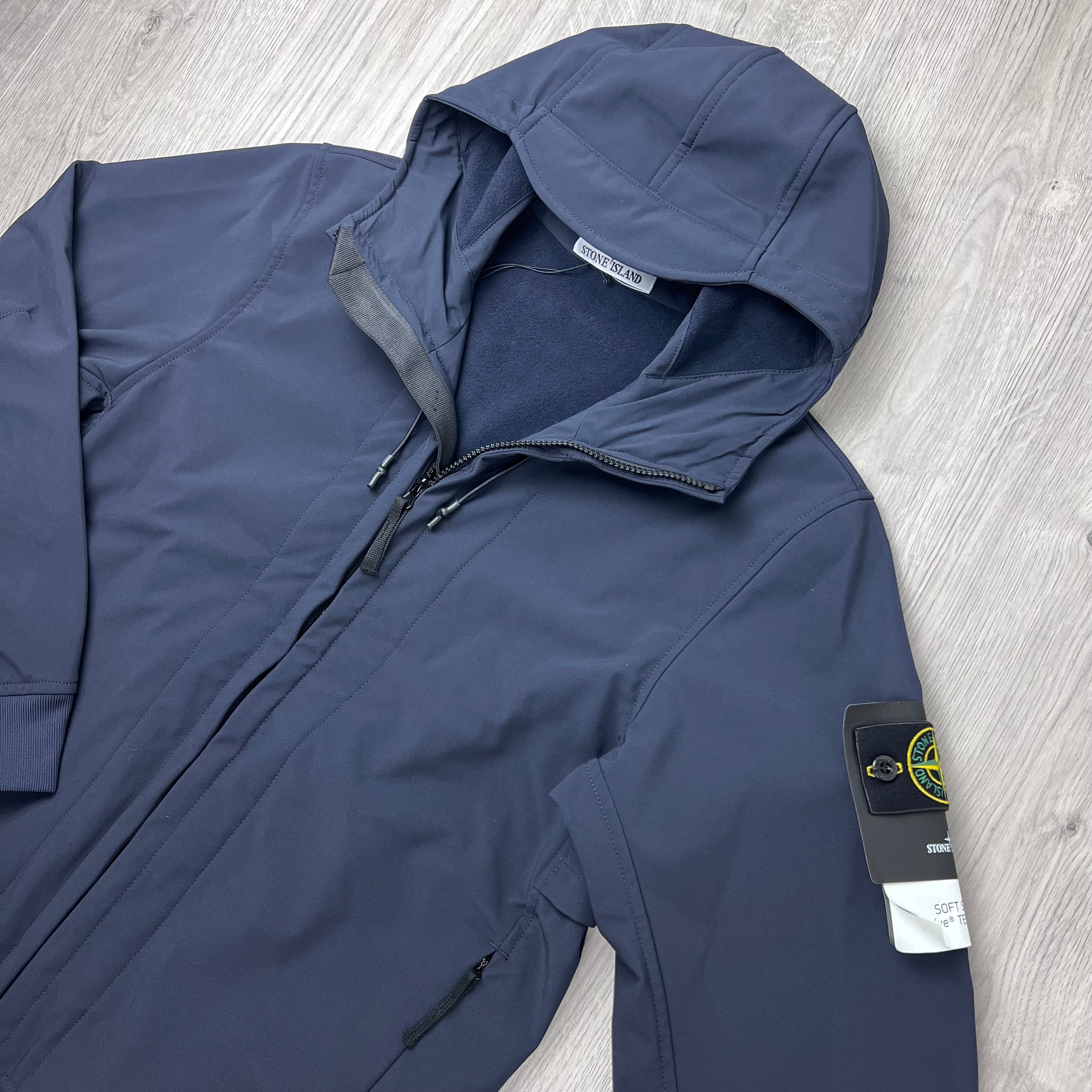 Angled view of the badge logo and hood on a Stone Island Soft Shell-R_e.dye® Jacket in Navy Blue.